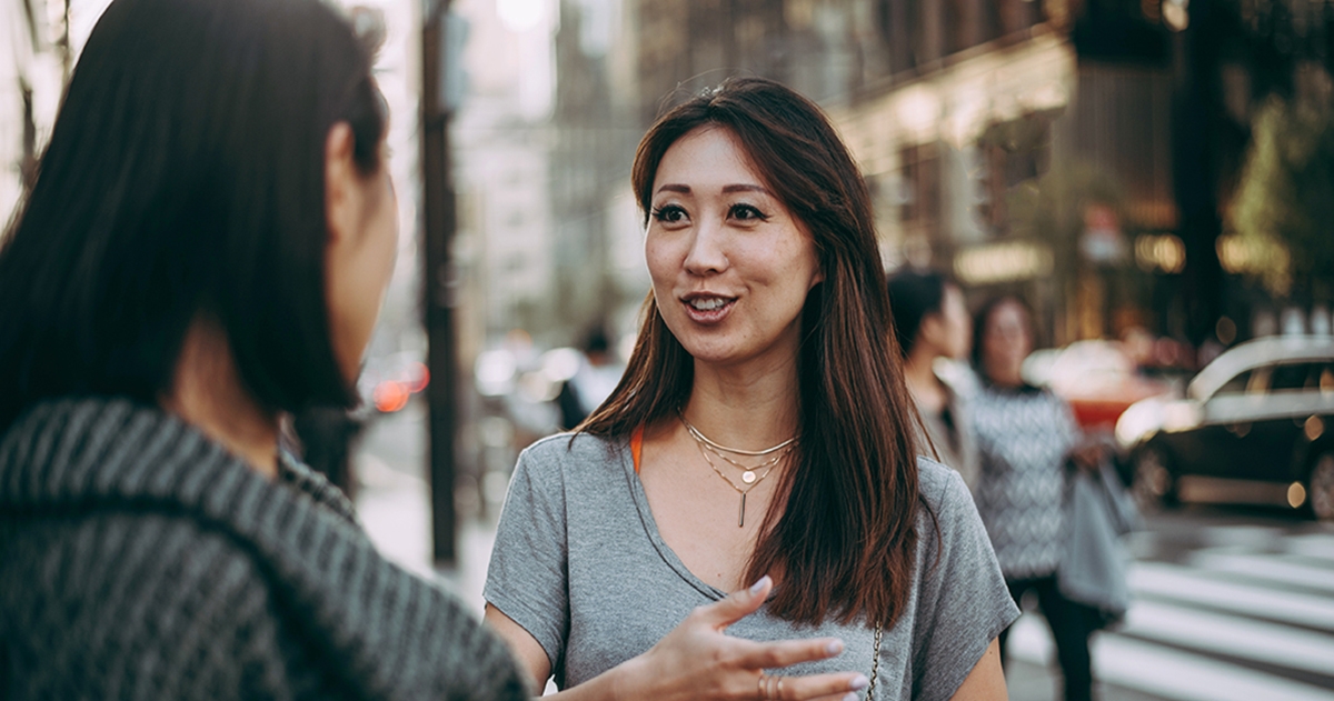 Woman greets her friend by saying hello in Chinese.