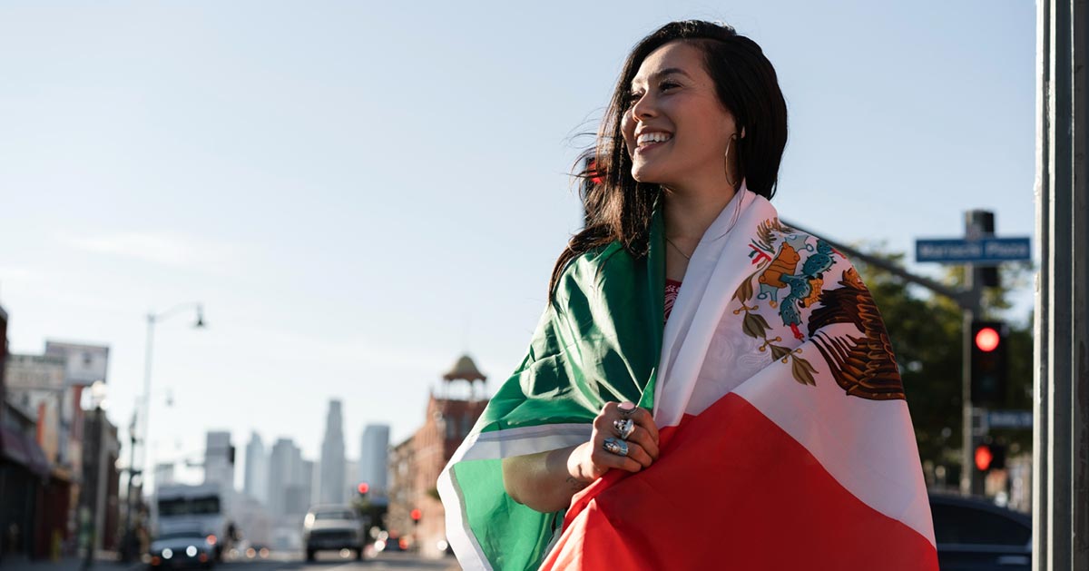 Woman carrying the Mexican flag.
