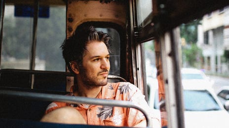 Young man riding a bus and gazing out the window, possibly reflecting on learning Vietnamese