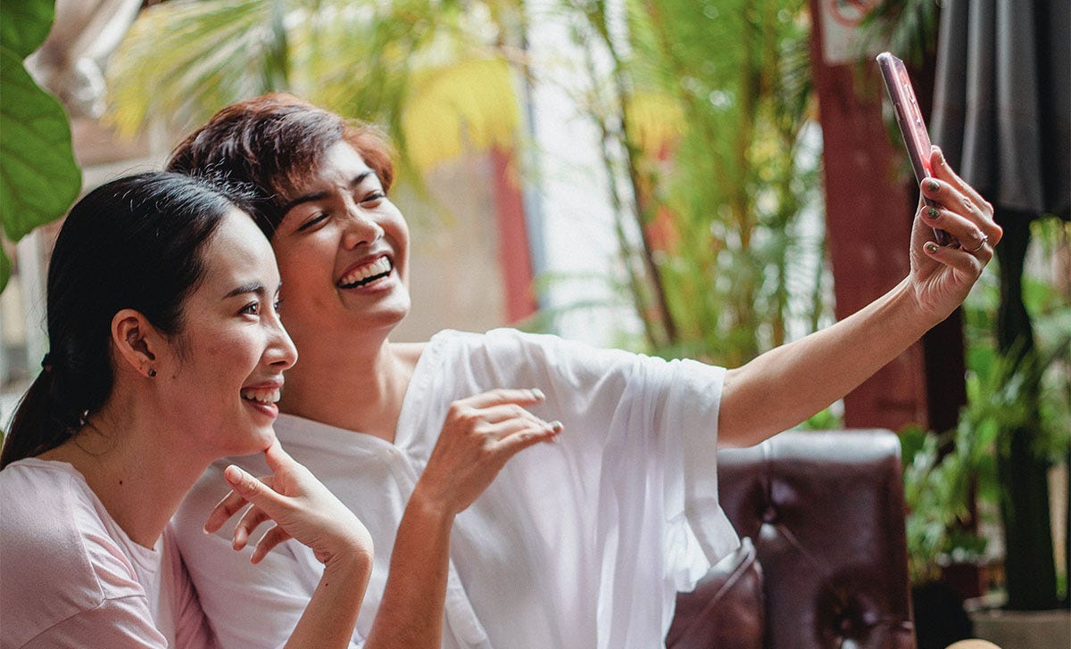 Two women taking a selfie to put on Chinese social media platforms.