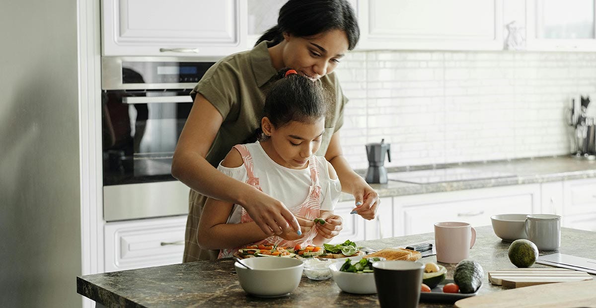 Mother and daughter cooking Spanish food in their kitchen.