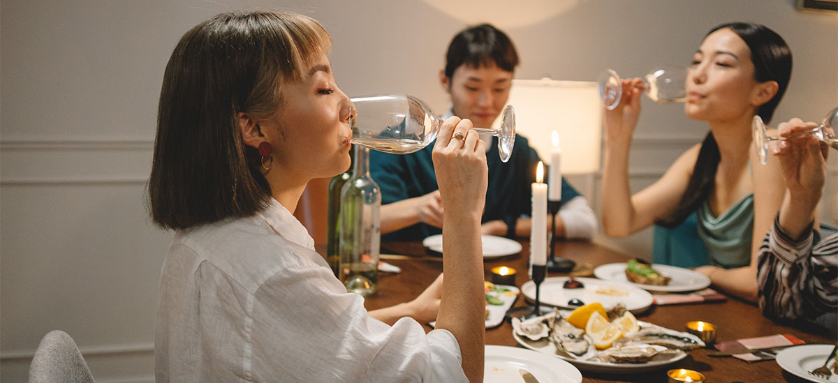 Women sharing a bottle of wine with dinner.