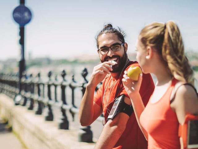 Two active young adults in workout gear enjoying a break outdoors, symbolizing flexibility and lifestyle balance with online German classes.
