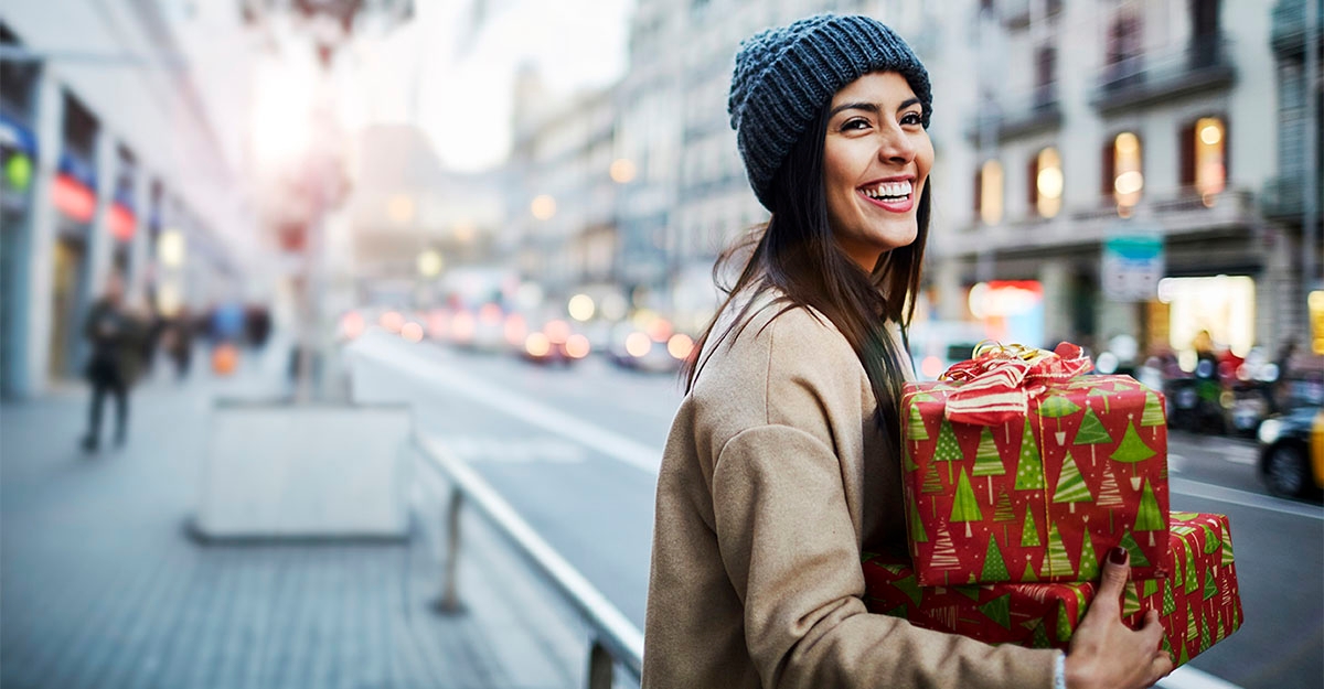 Woman carrying Christmas presents for a very merry Christmas in German.