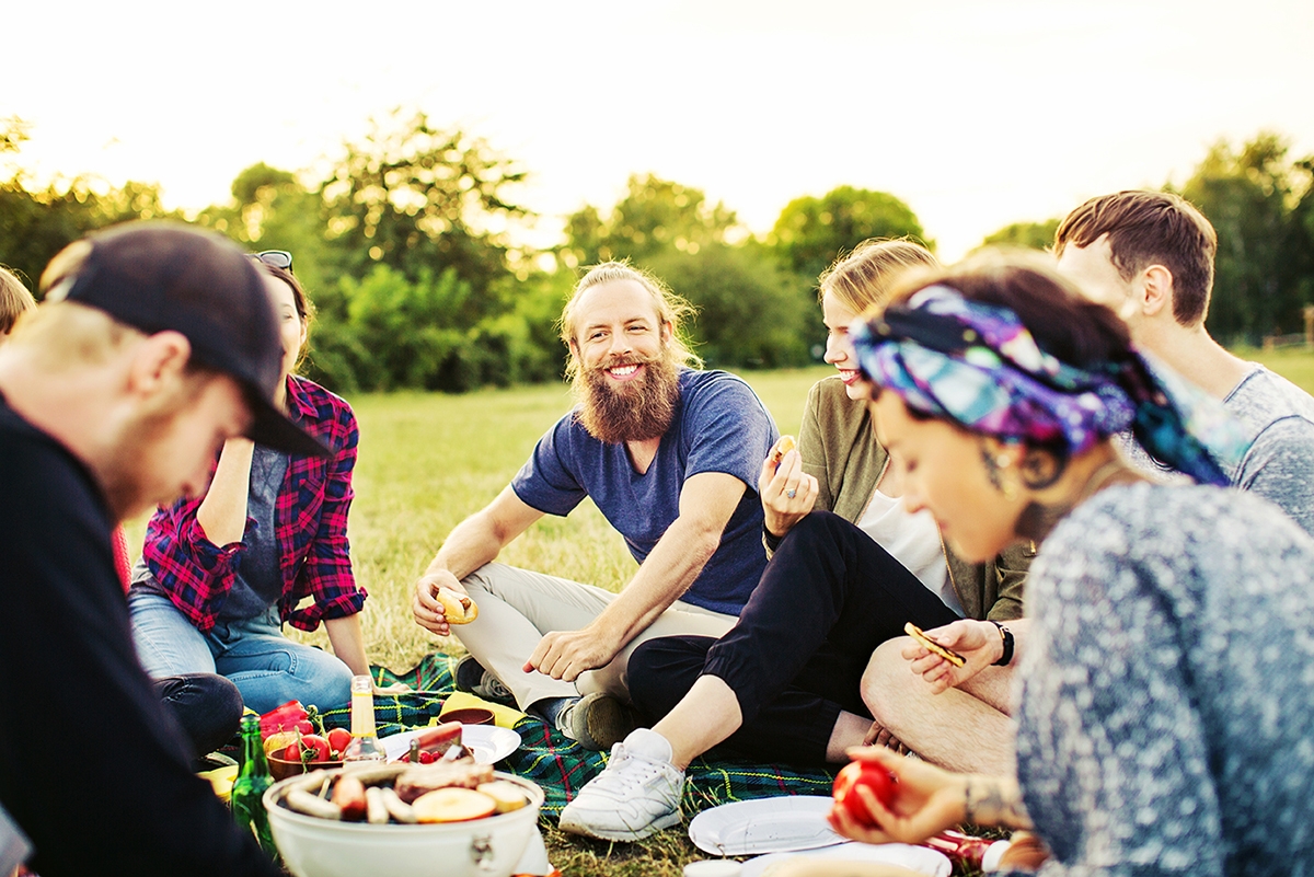 Group of friends enjoying a picnic and speaking French Canadian slang.