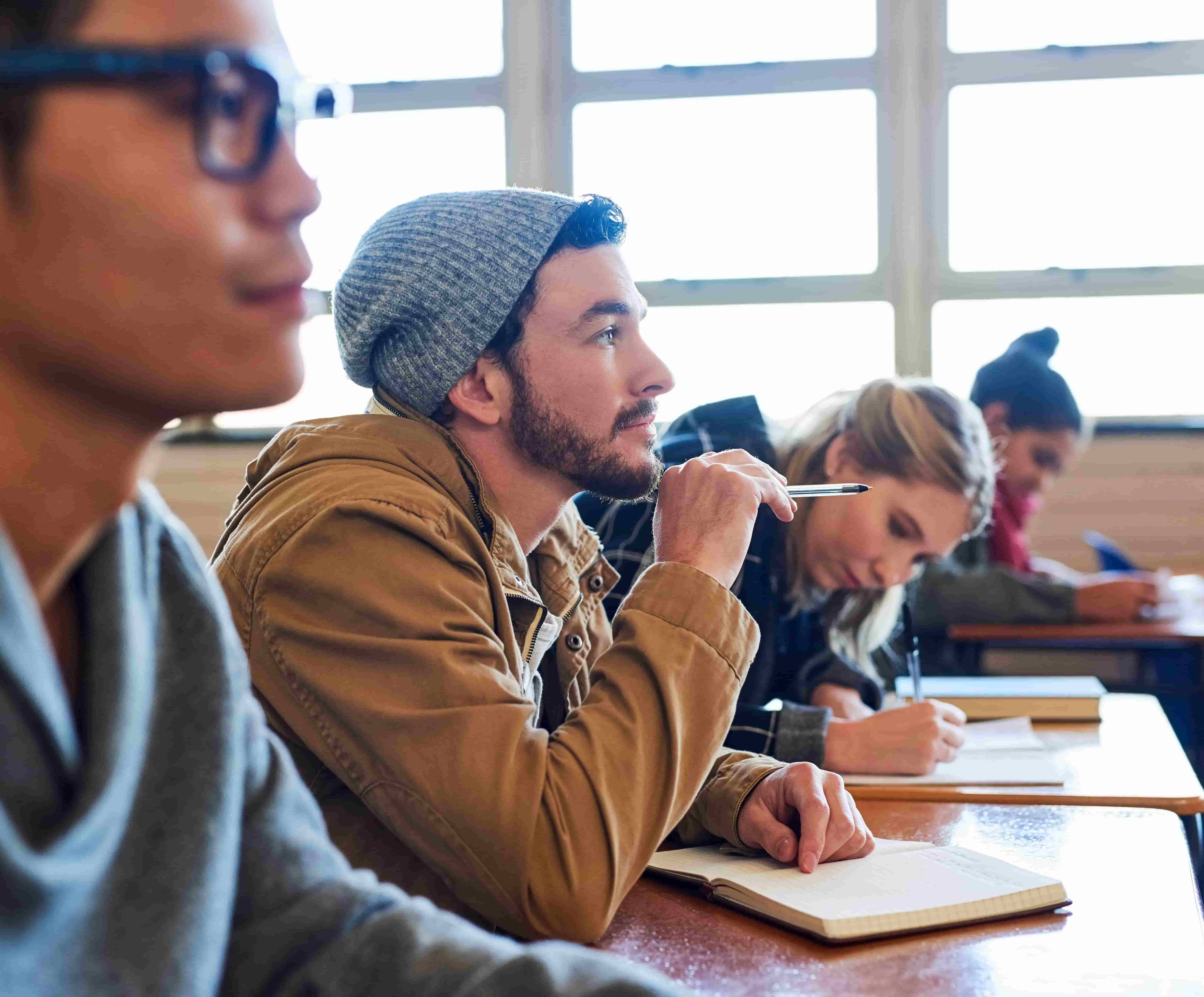 Students focused in class, listening and taking notes.