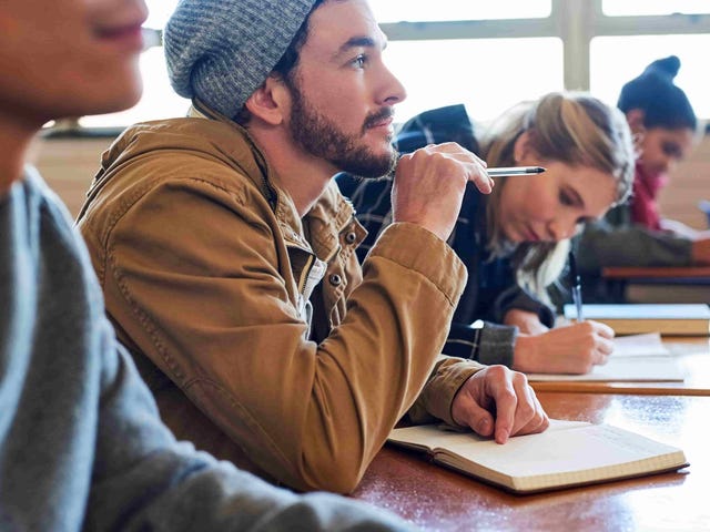 Students focused in class, listening and taking notes.