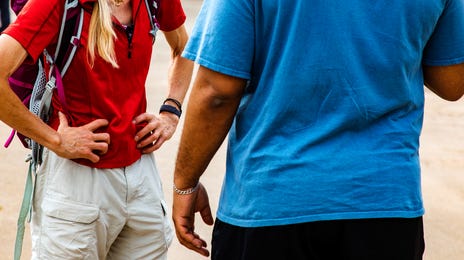 A group of hikers at a meeting point discussing their adventure, symbolizing learning Kannada through real-life interactions.