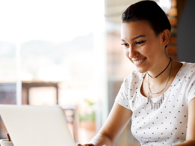 Smiling young professional working remotely on a laptop, representing the flexible and global opportunities available through Berlitz careers.
