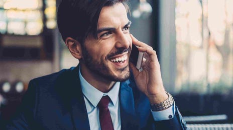 Smiling professional speaking on the phone with a tablet in hand, representing the flexibility and global reach of Berlitz teaching English jobs.
