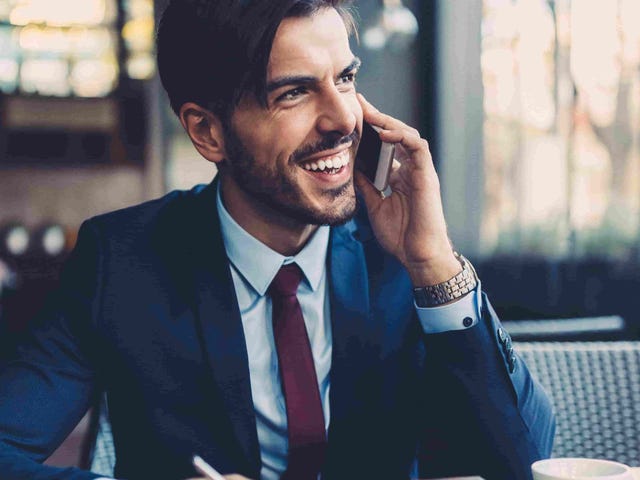 Smiling professional speaking on the phone with a tablet in hand, representing the flexibility and global reach of Berlitz teaching English jobs.