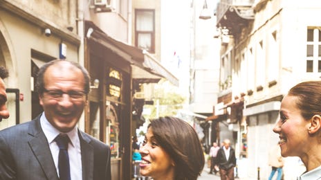 Business professionals laughing and interacting outdoors, illustrating positive outcomes of corporate culture training