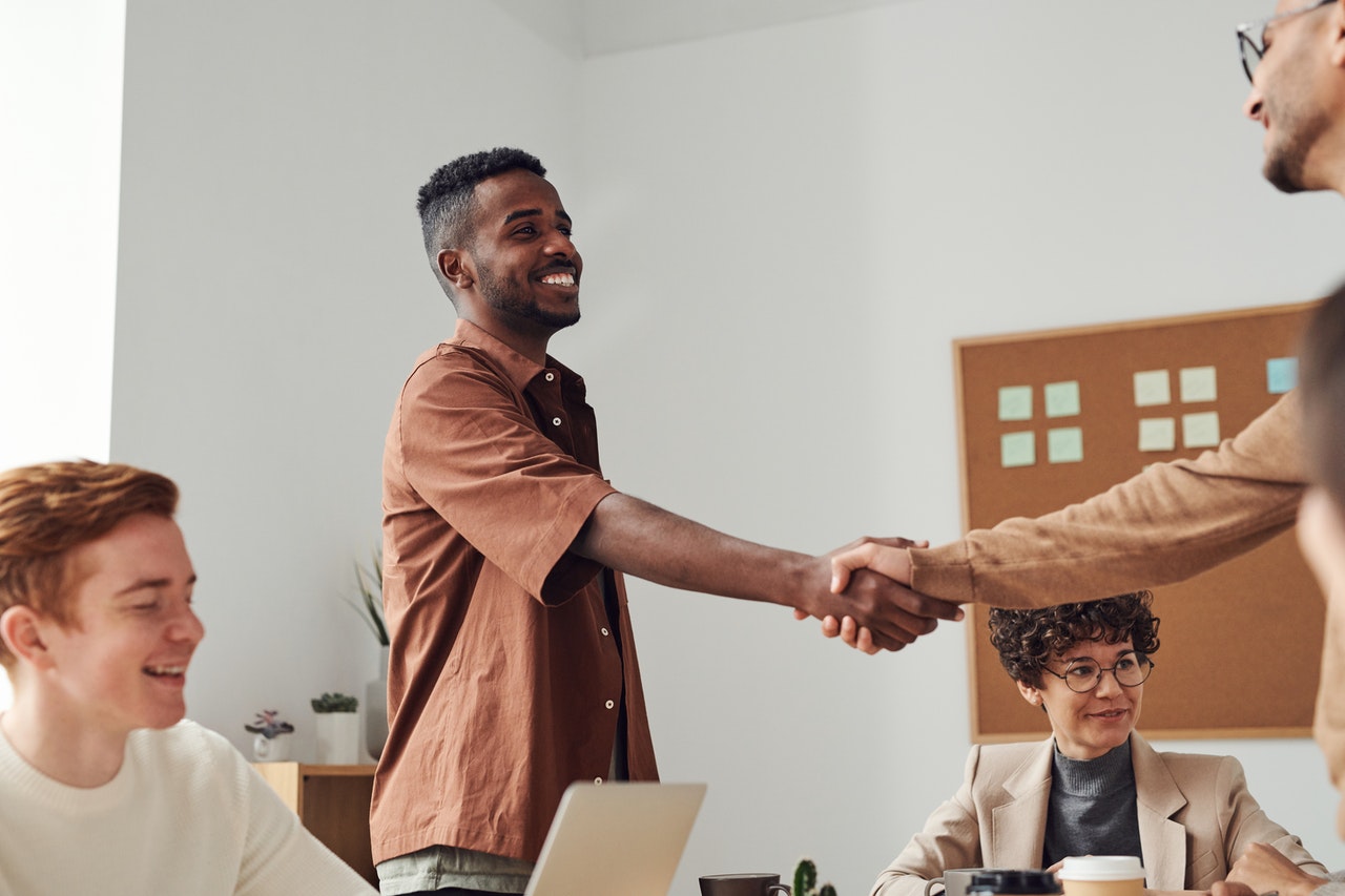 A man greeting a colleague with a formal hello in Italian.