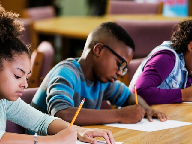 A diverse group of elementary school children focused on writing during a classroom language learning program