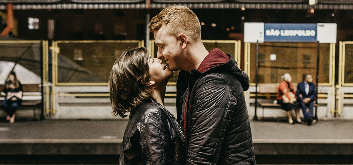 Couple kiss goodnight in German train station.