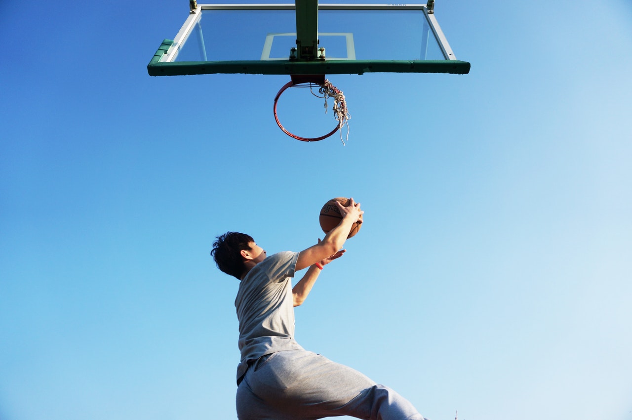 Man playing basketball has better reaction times after learning sign language.