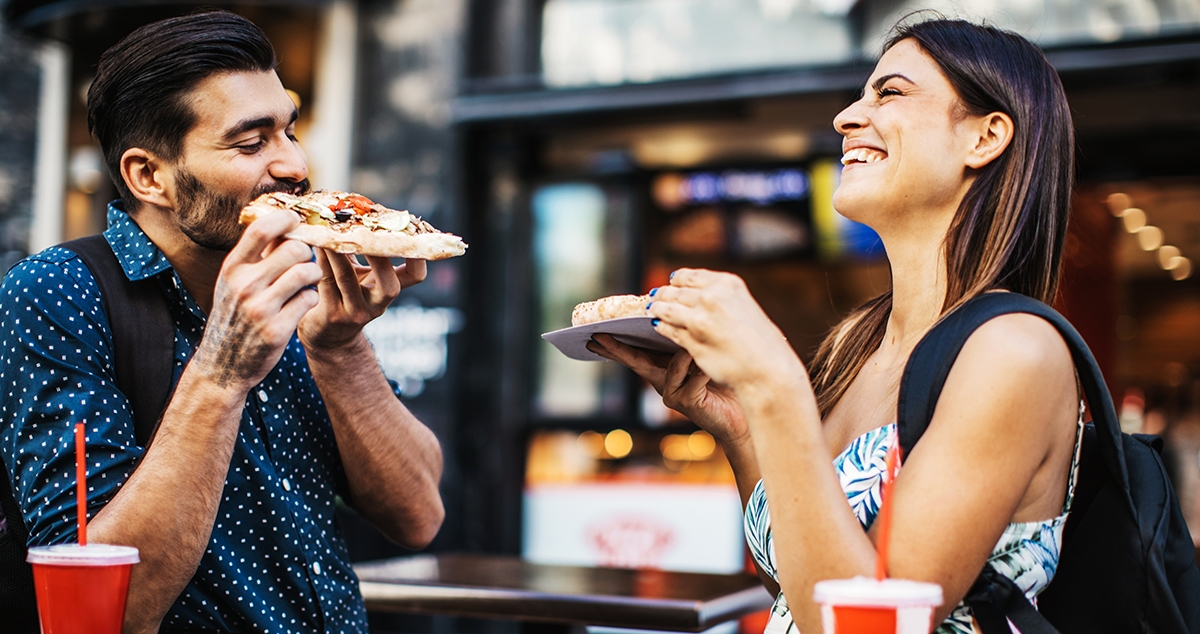 Couple enjoy pizza and say thank you in Italian.