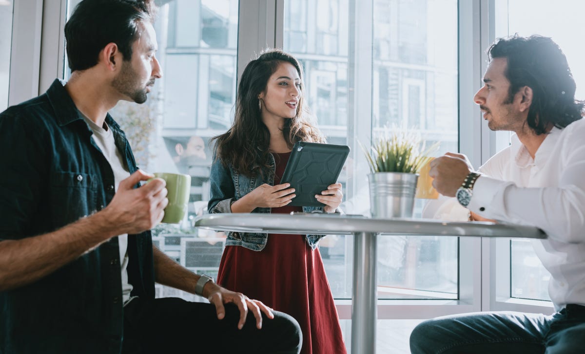 Group of adults having a discussion during an Urdu language class at a café-style learning space