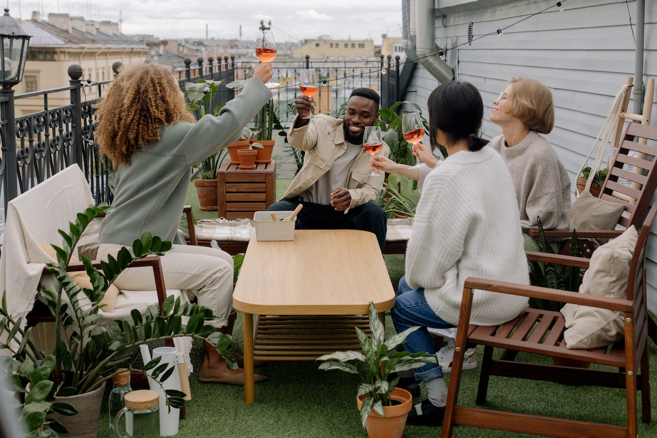 Happy diverse friends saying cheers to the longest words in French with Aperol Spritz rose wine.