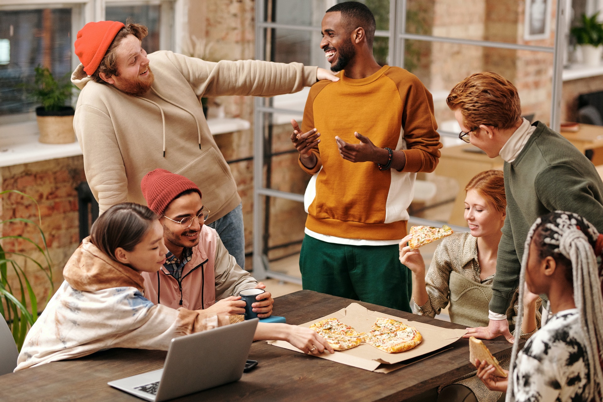 Nicknames in Spanish for a group of friends eating pizza and laughing.