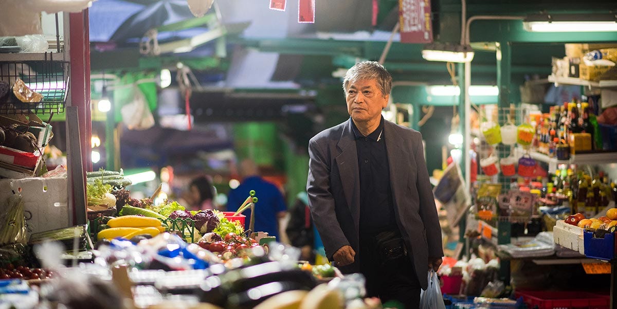 Man walking through a Chinese food market.