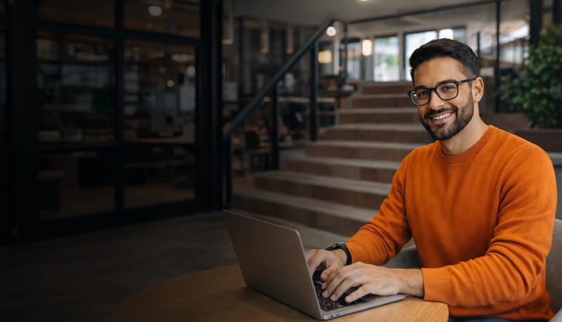guyonlaptop-smilingatcamera.webp