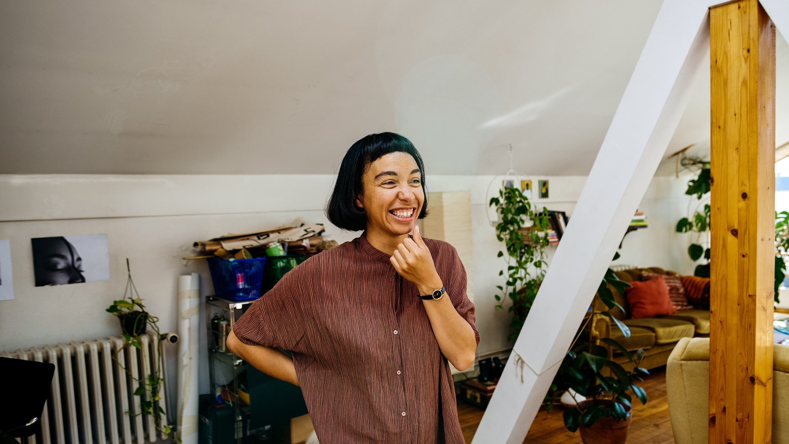 A woman touches her chin and laughs.