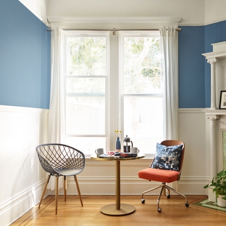 غرفة معيشة زرقاء اللون مع مدفأة في الزاوية.