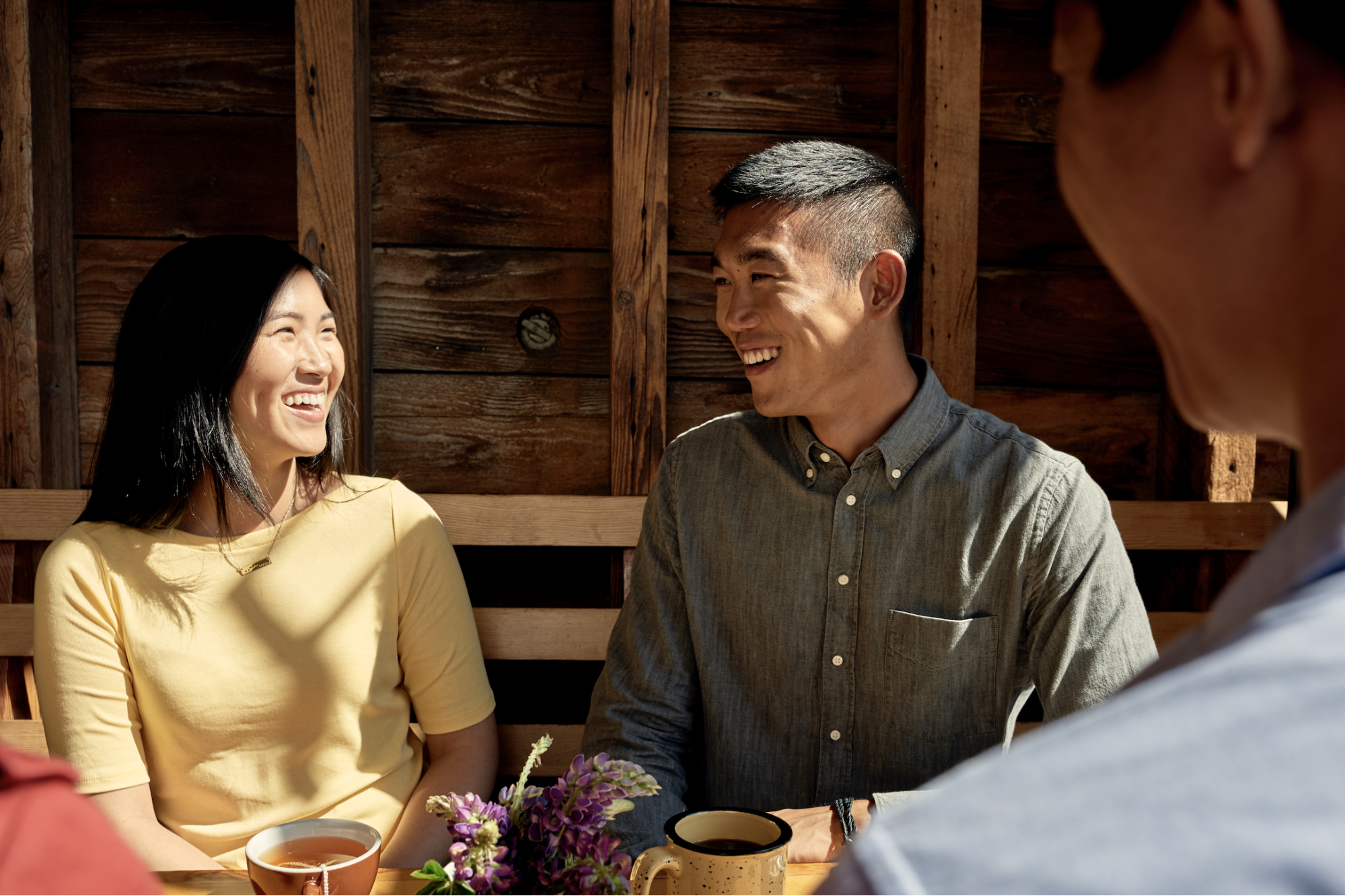 Um homem e uma mulher sorriem um para o outro bebendo chá.