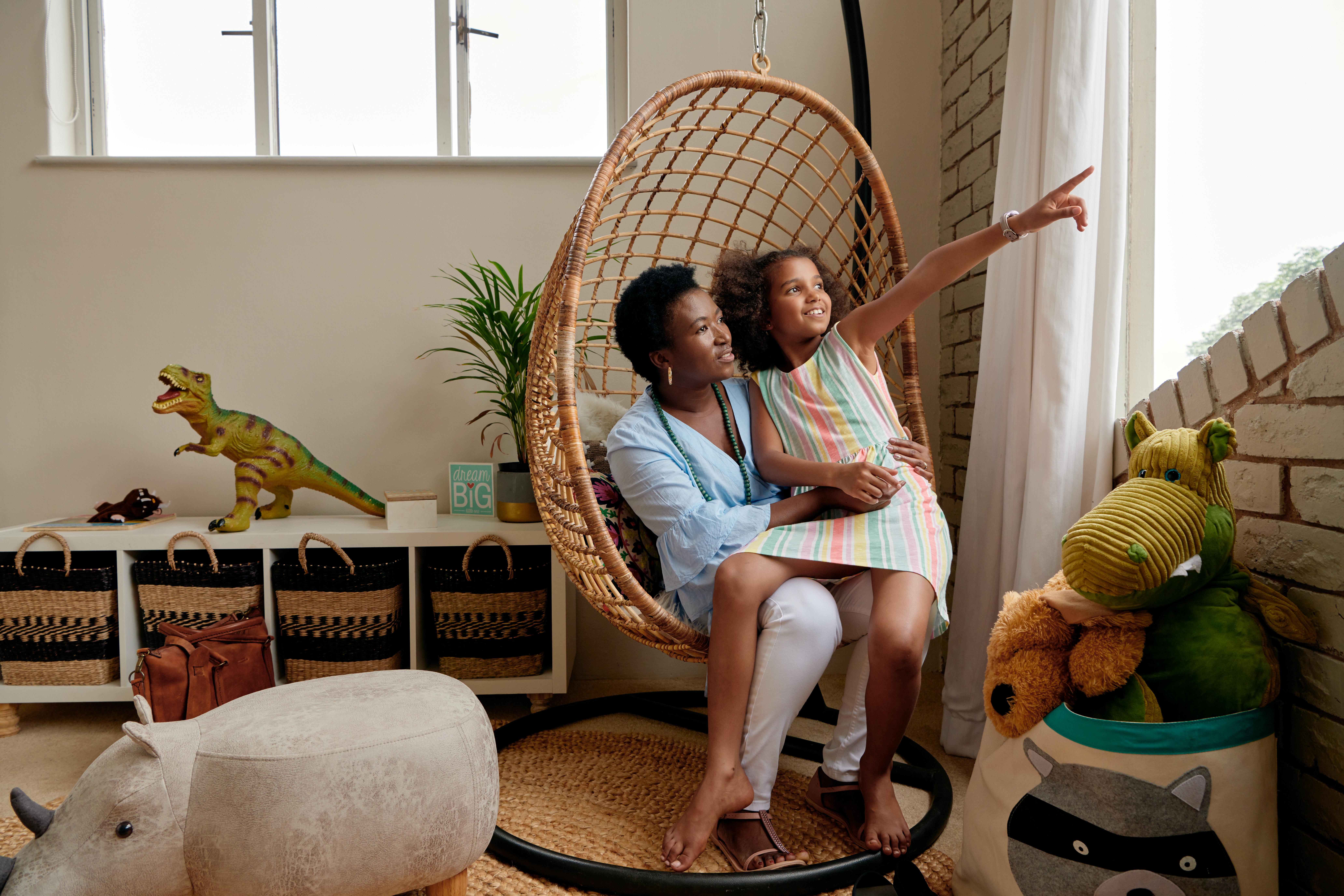 Una imagen de un anfitrión en Airbnb y un niño sentados juntos en una sala llena de juguetes.