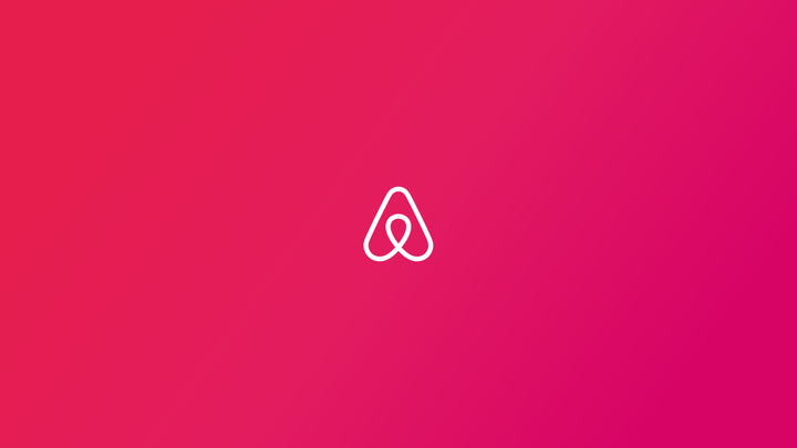 Airbnb Bélo, il-logo ta' Airbnb, b'lewn abjad fuq sfond aħmar.