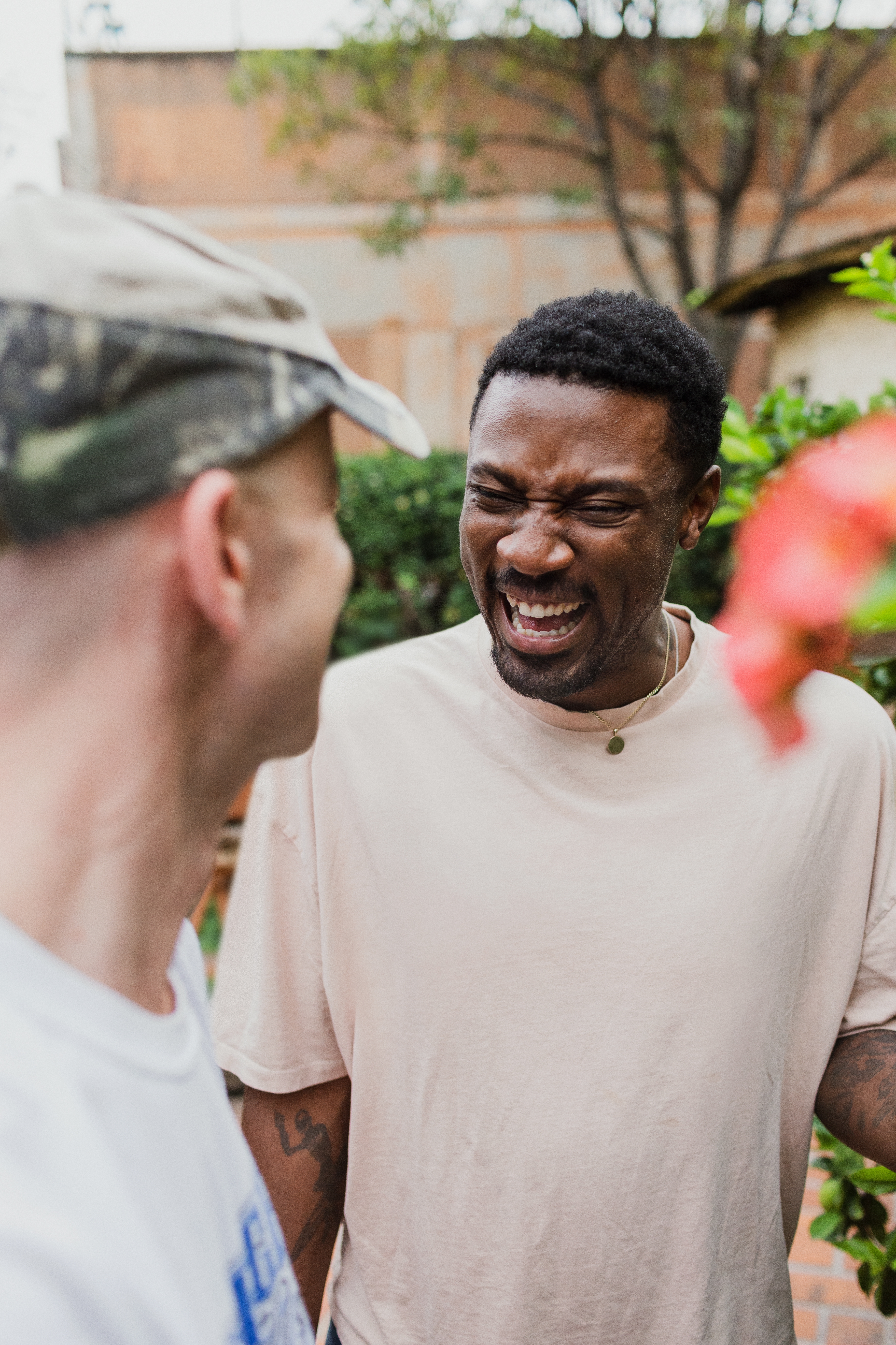 Dos personas ríen juntas. Una de ellas está de frente a la cámara y la otra está de espaldas.