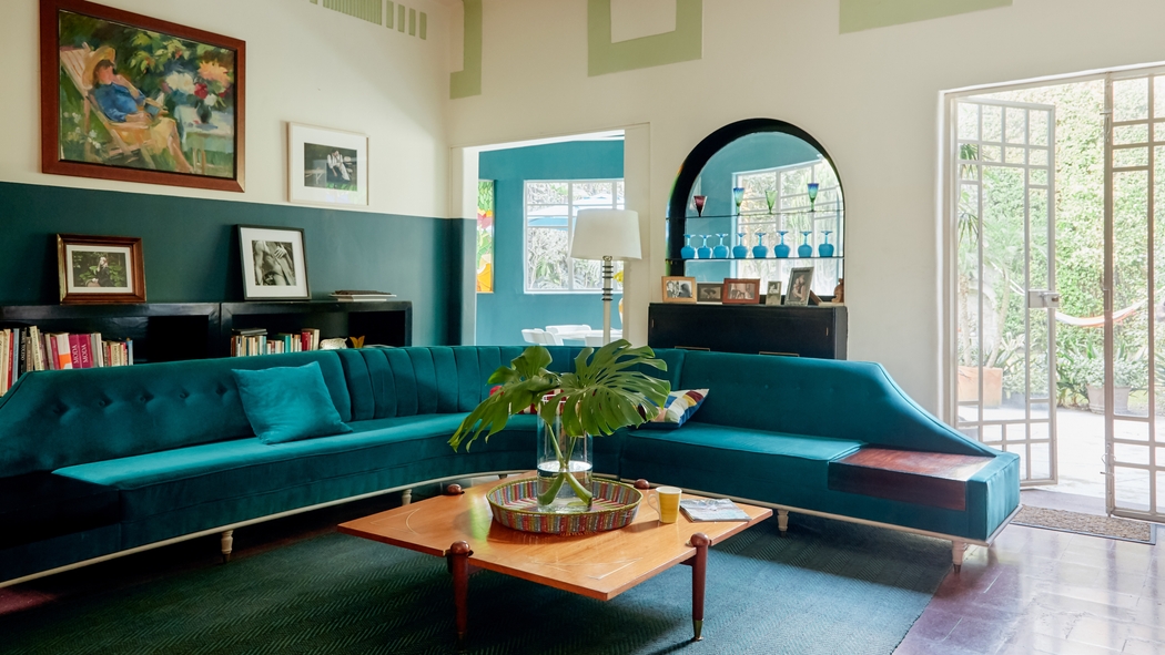 A bright and airy living room with a turquoise couch.