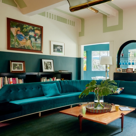 Un salon lumineux et spacieux avec un canapé turquoise.