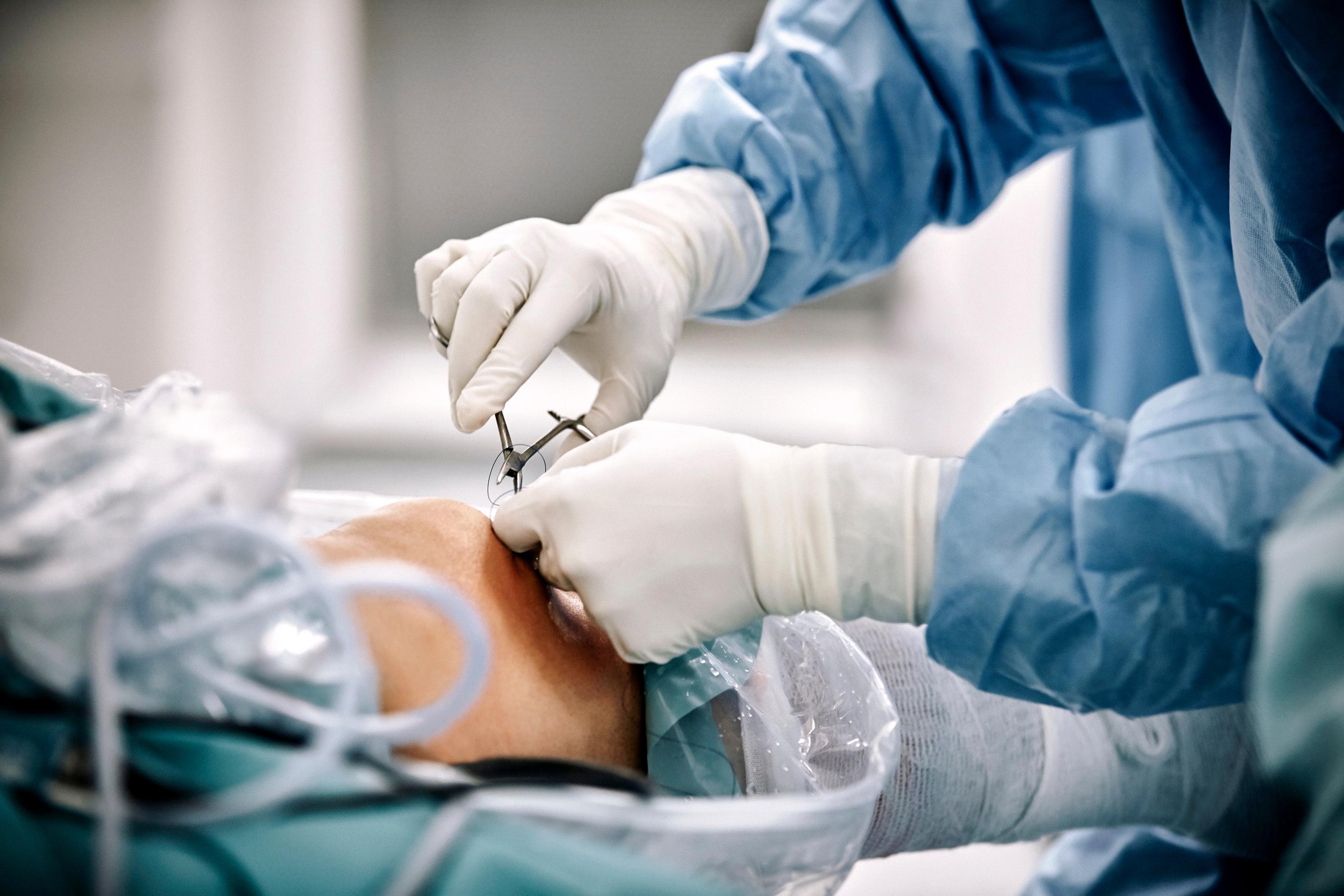 JJ_Photo_Gloved_hands_cutting_stitches_on_knee_GettyImages_1010678728_4Star.jpg