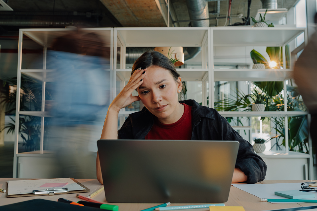 Woman looking worried at a laptop screen