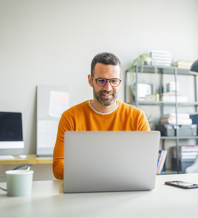 Man smiling at a laptop