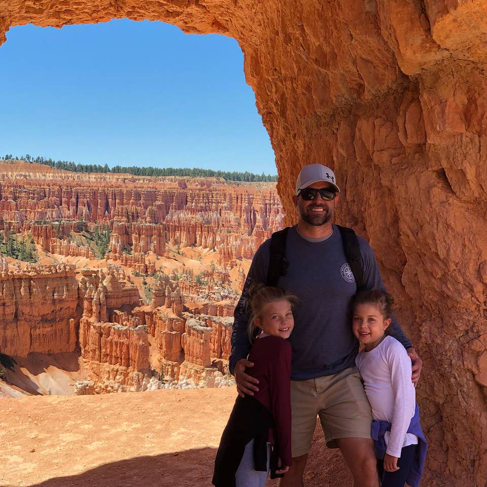 Josh (middle), Kyler (right) and Kyndall (left) stand under an arch formation in front of a gorge.