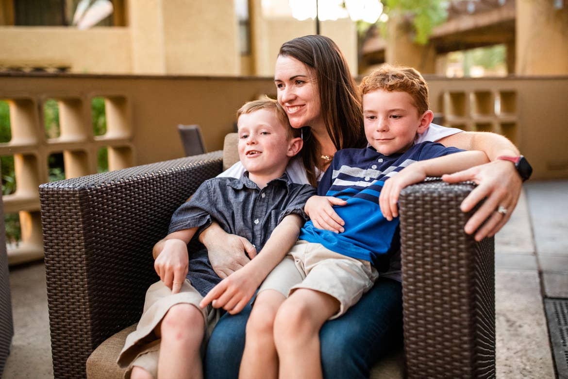 Author Jessica Averett (middle) holds her two sons (left, right) on a chair outside the Scottsdale Resort patio.