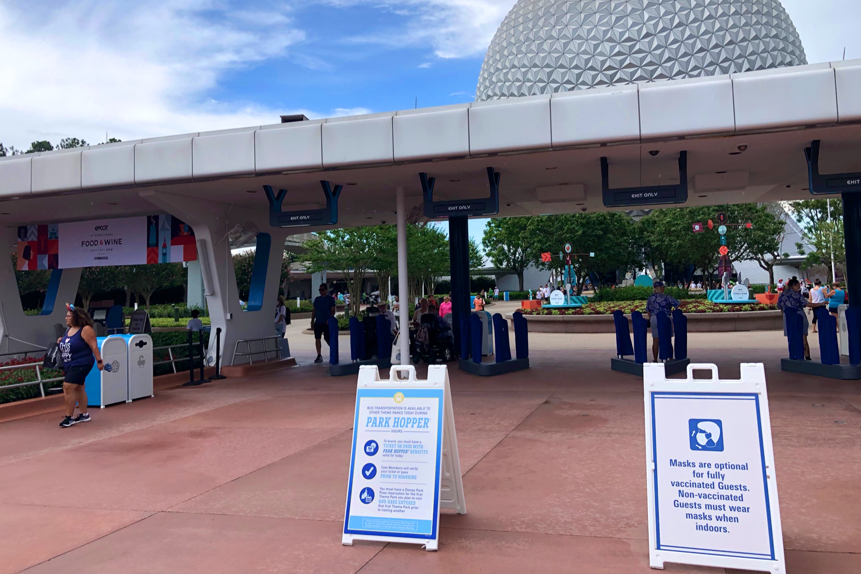 The security entrance to Epcot with two signs indicating CDC safety guidelines for guests conduct in the parks.