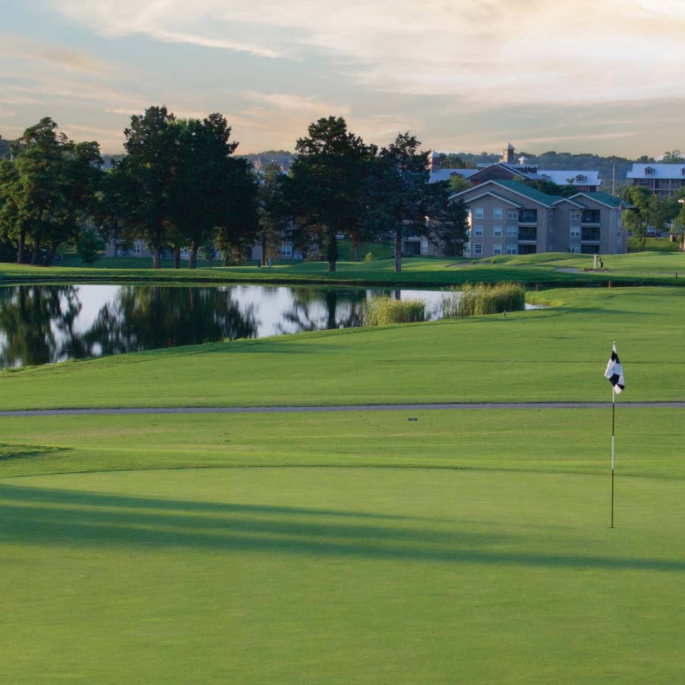 Golf course with property buildings and lake in the background at Holiday Hills Resort in Branson, Missouri.