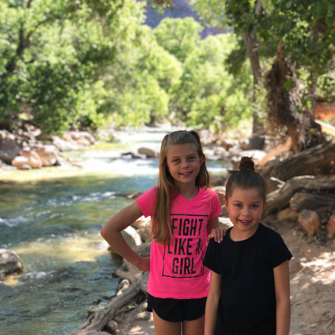 Kyndall (left) and Kyler (right) stand in front of a lush creek in Zion.