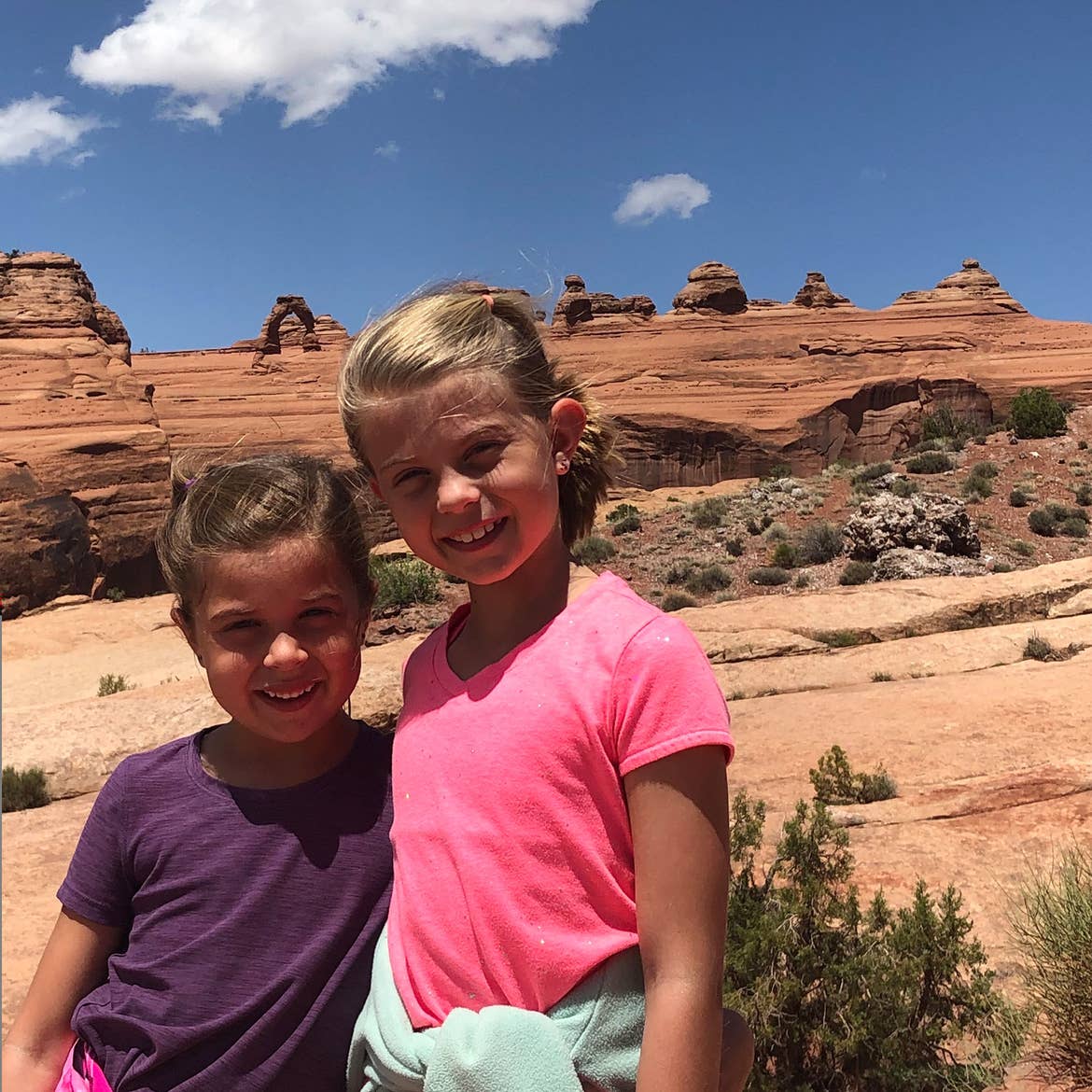 Kyndall and Kyler stand in front of the mountains of Red Rocks.