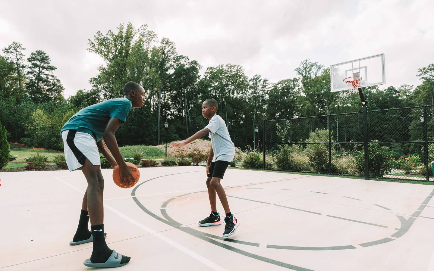 Adult and child playing basketball outdoors at Williamsburg Resort.