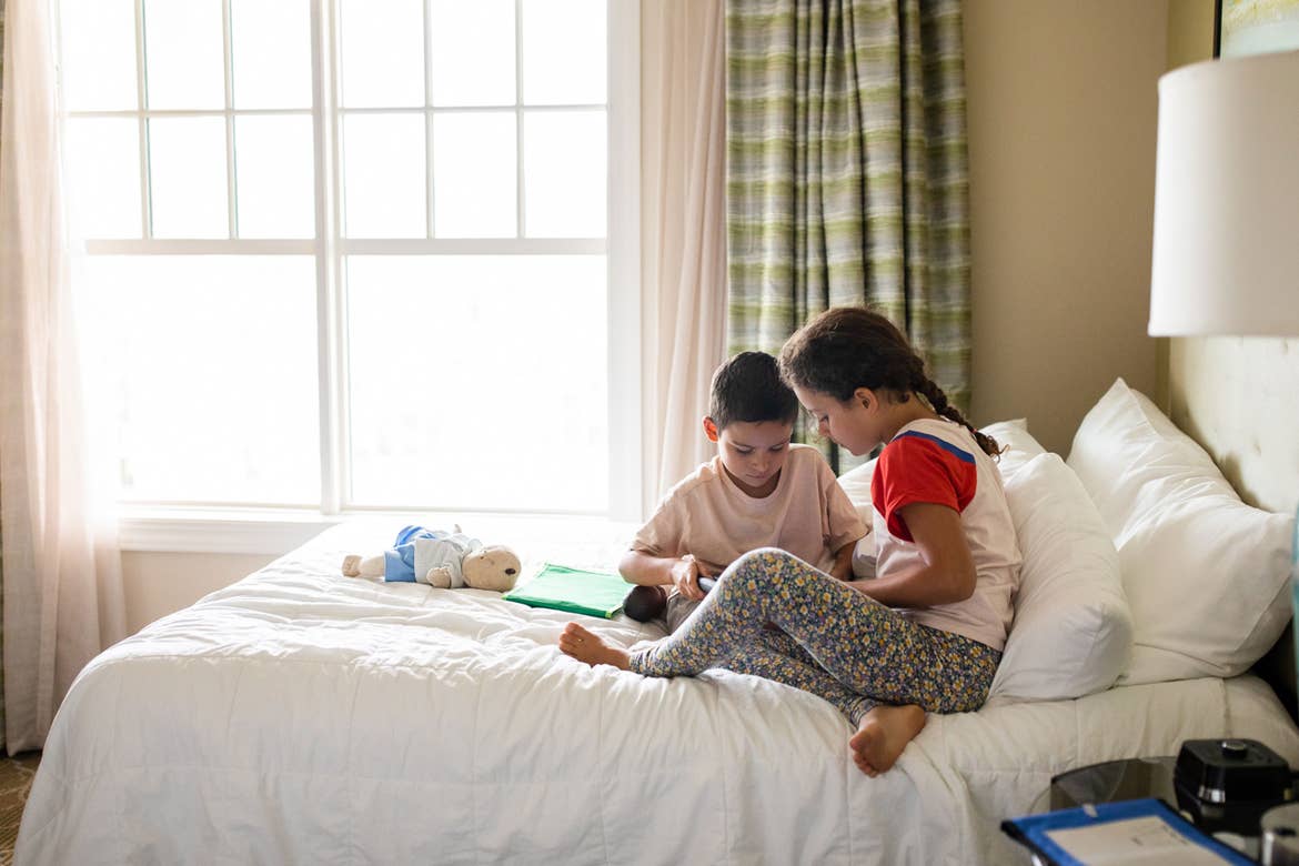 Brenda Rivera Sterns' two children sit in one of the bedrooms on a queen-sized bed in our Signature Collection villa at our South Beach Resort in Myrtle Beach, South Carolina.