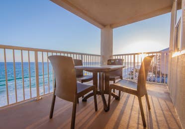 Furnished balcony with table and four chairs and view of ocean at Panama City Beach Resort