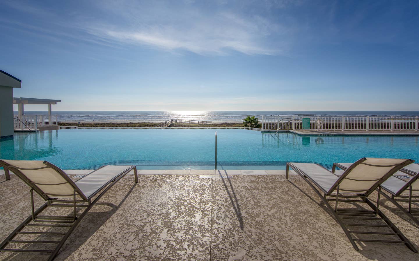 Outdoor oceanfront pool with sun chairs at Galveston Seaside Resort.