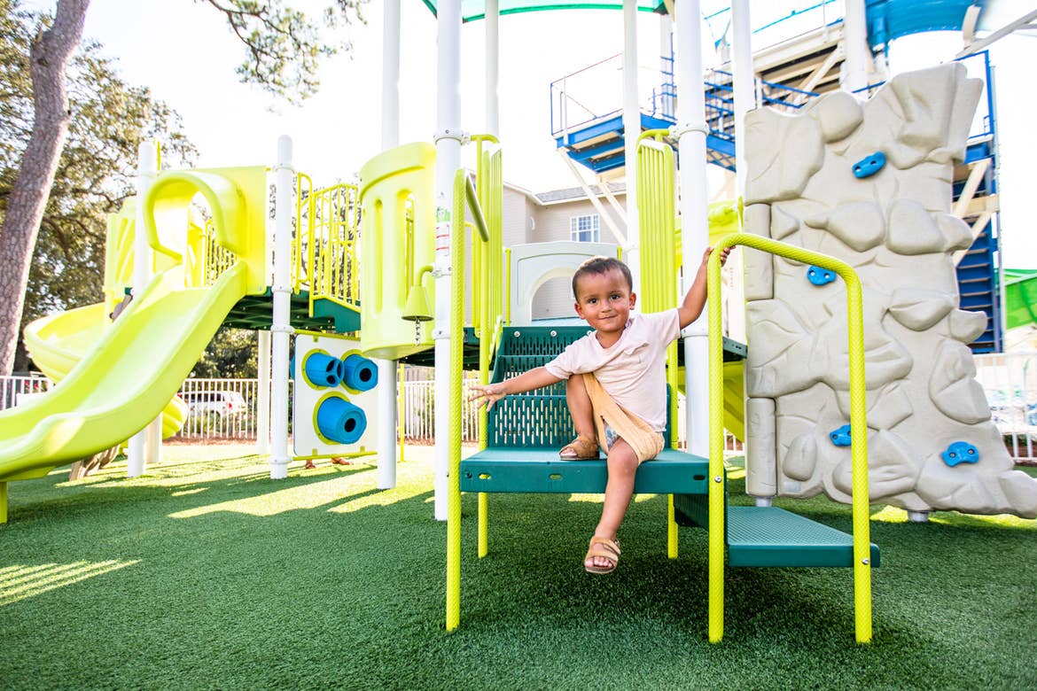 Author, Brenda Rivera Stearns' son climbs the green steps of our playground at our South Beach resort in Myrtle Beach, South Carolina.