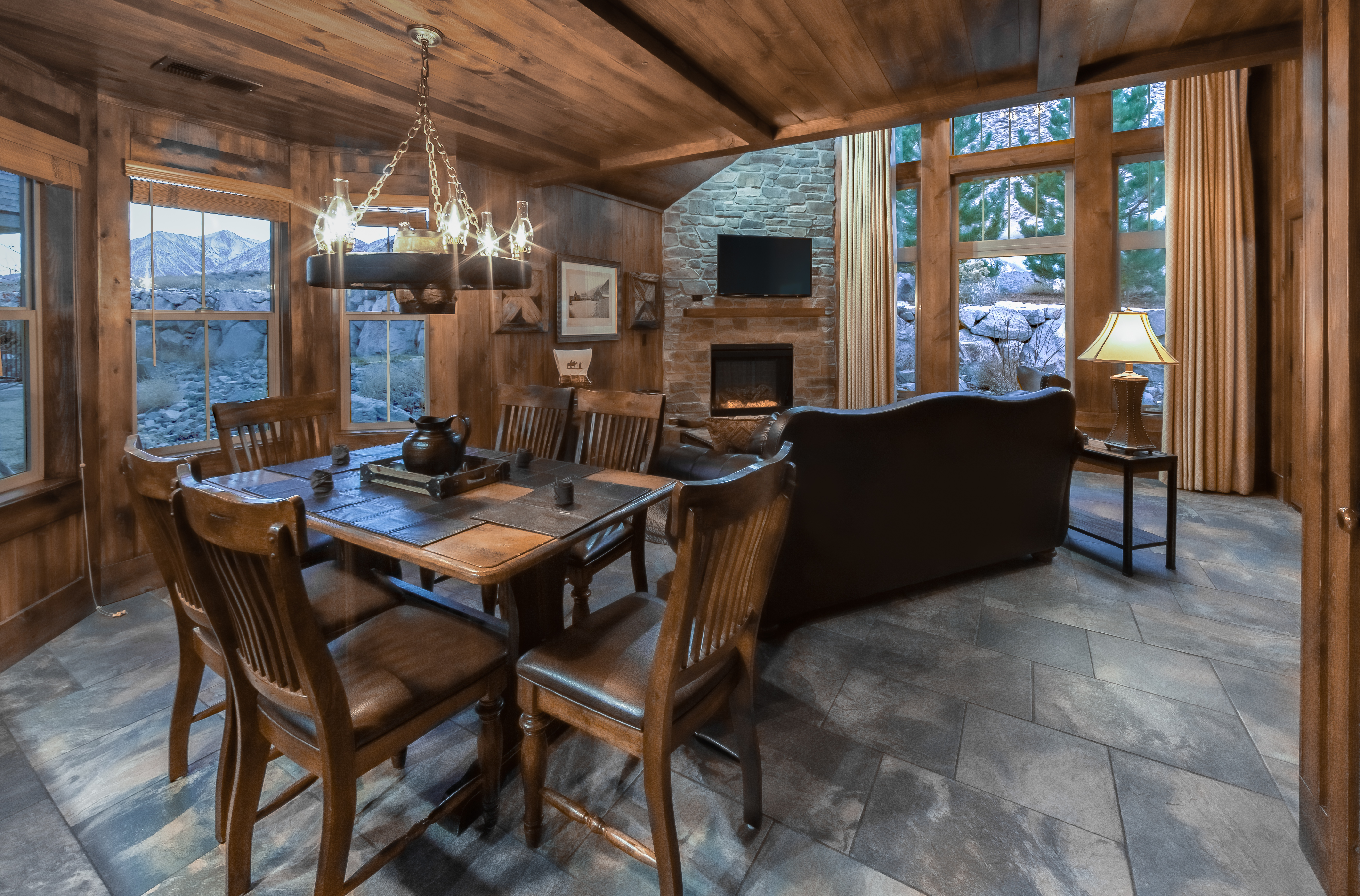 Dining area with living room and fireplace in background in a deluxe three-bedroom cottage at David Walley's Resort in Genoa, Nevada