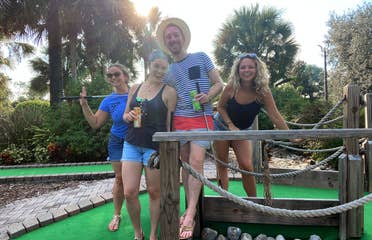 Featured Contributor, Angie Orth (far-right), and her friends hold their putters outside on our mini-golf course.